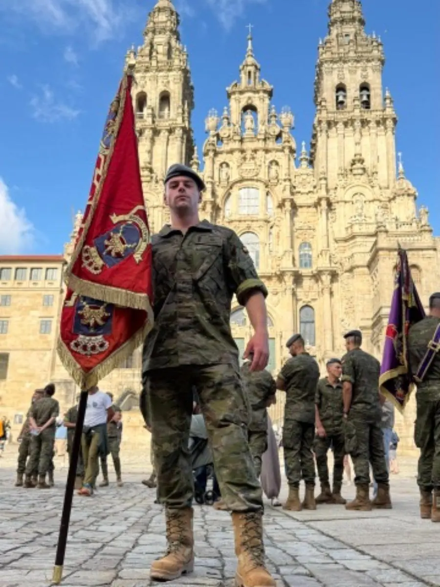 Antonio Jamart con uniforme militar y un estandarte frente a la catedral de Santiago de Compostela