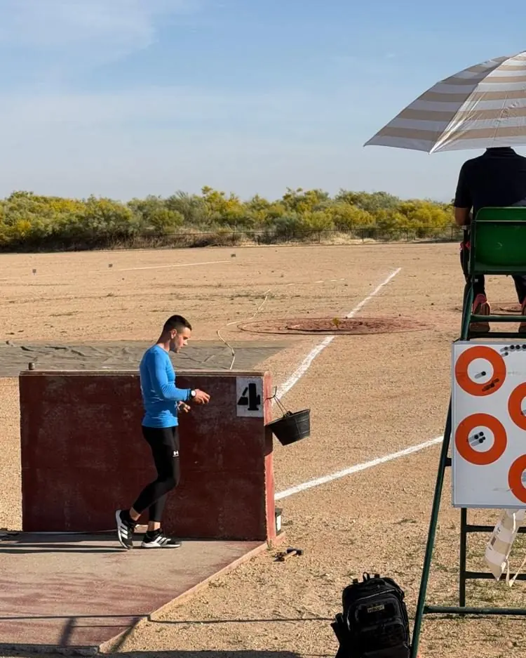 Antonio Jamart en un puesto de una prueba de tiro, con un juez supervisando desde su silla