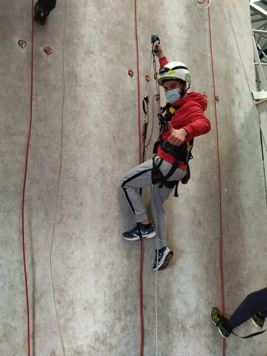Antonio Jamart con casco y arnés ascendiendo por cuerda en una pared de entrenamiento vertical