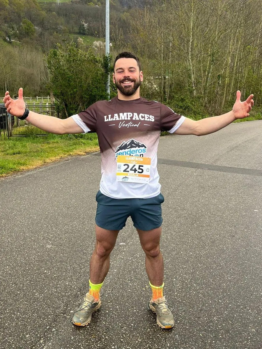 Antonio Jamart sonriendo con los brazos abiertos tras una carrera de montaña, con dorsal y zapatillas de trail
